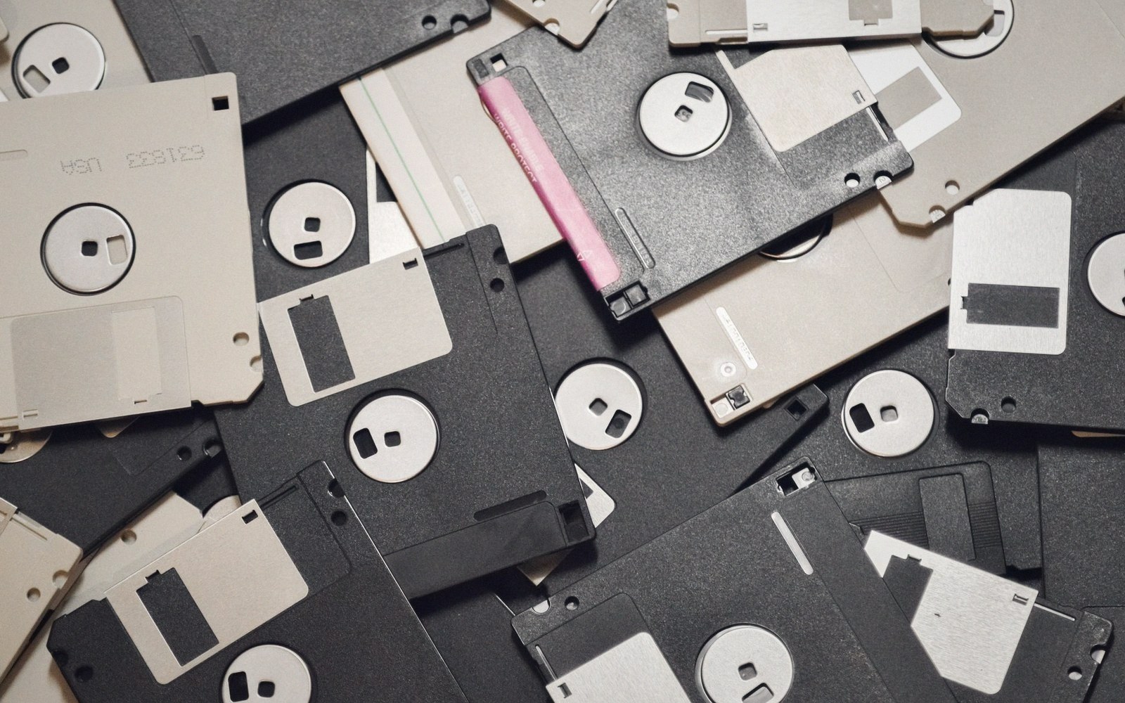 A jumbled pile of black and gray 3.5-inch floppy disks