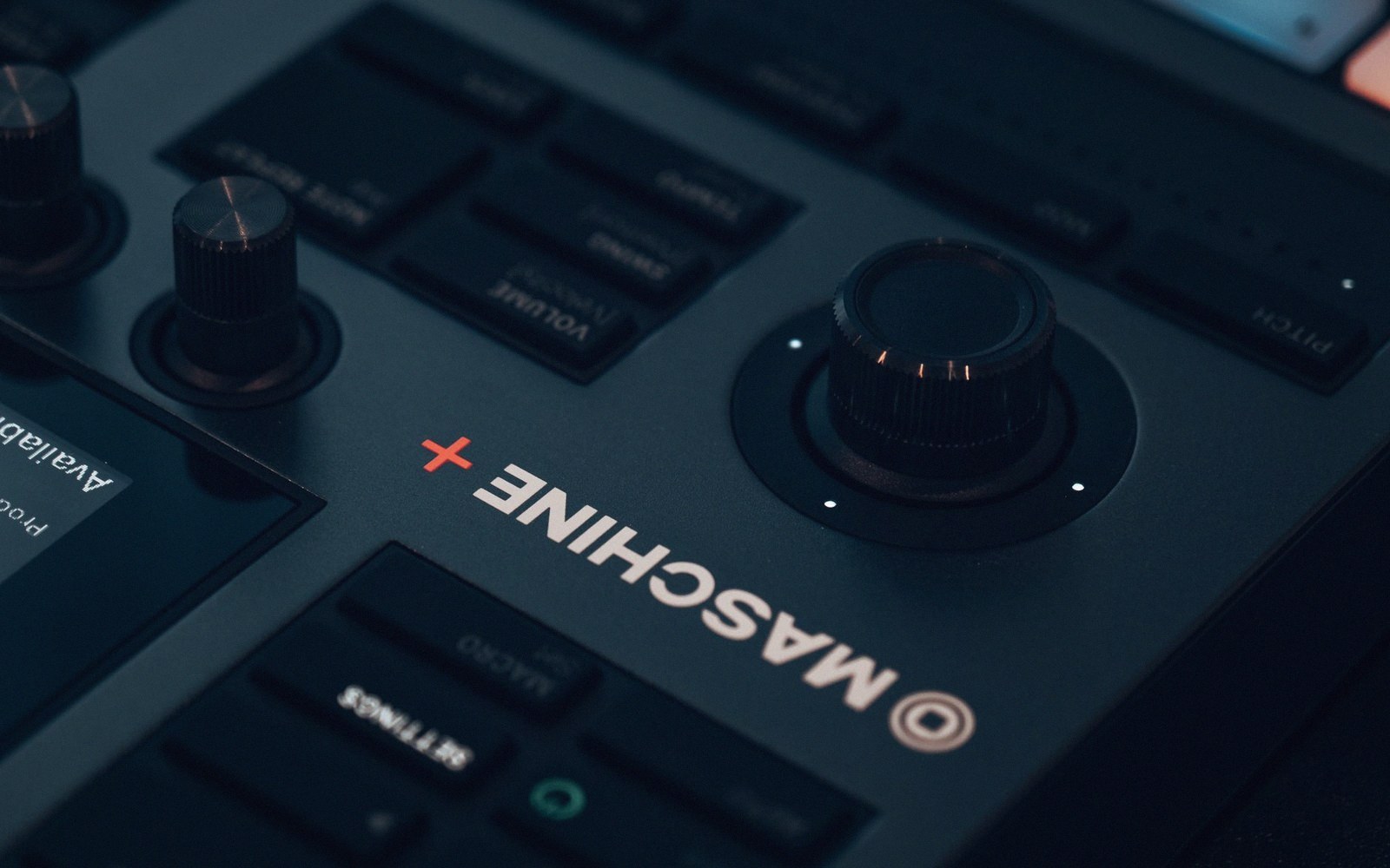 Close-up of a Maschine controller's main knob and logo with volume and pitch dials