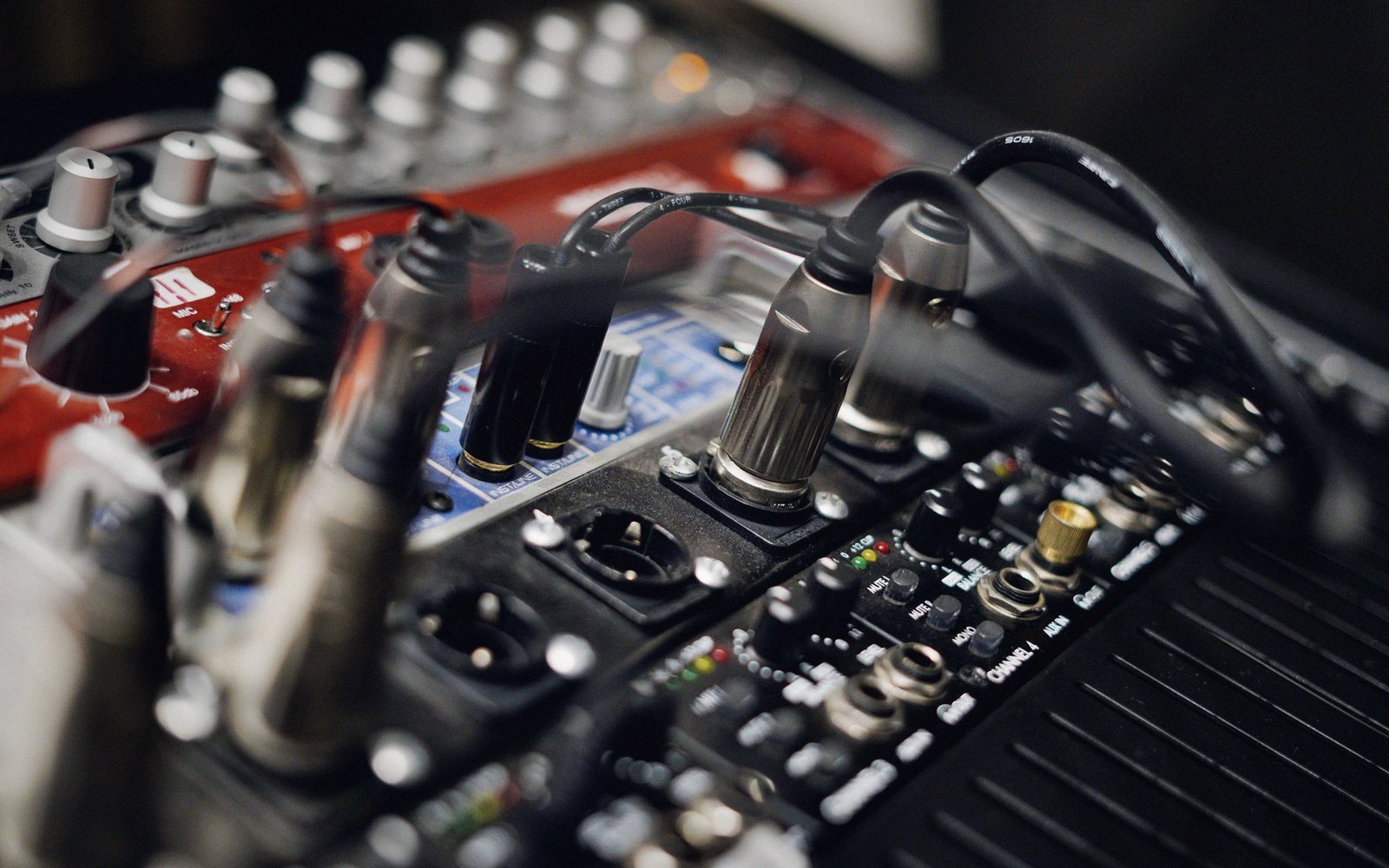 Cables and XLR connectors plugged into a mixing console's input channels